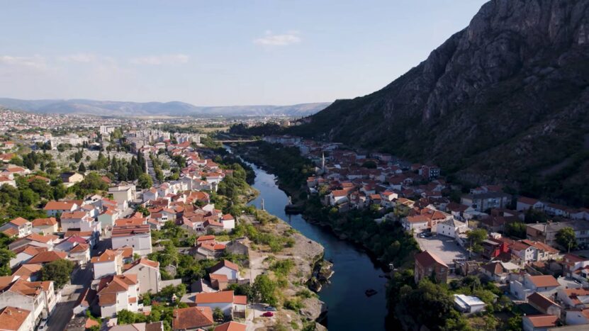 The Neretva River flows through Mostar, a historic city surrounded by mountains in Bosnia and Herzegovina.